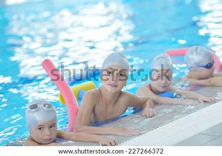 group of happy kids children   at swimming pool class  learning to swim
