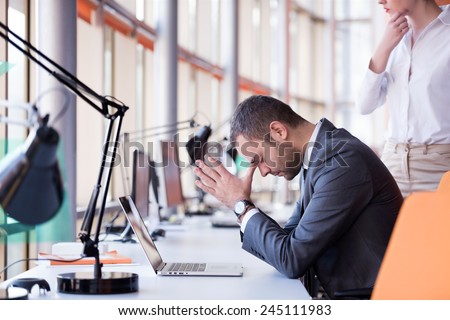 frustrated young business man working on laptop computer at office