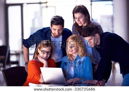 students group working on school  project  together on tablet computer  at modern university