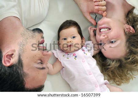 indoor portrait with happy young family and  cute little baby