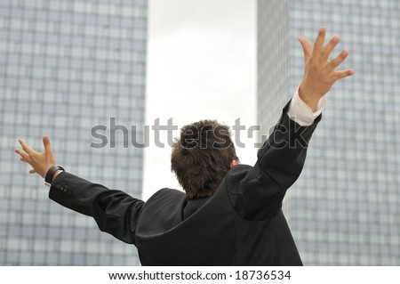 Outdoor portrait of young, happy  winner businessman with arms wide open