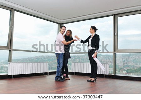 happy young couple buying new home with real estate agent and  looking big comfort bright apartment plans and taking key