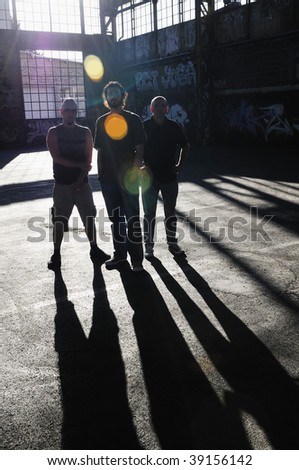 group of three adult man outdoor in the city at the sunset representing urban and modern everyday scene