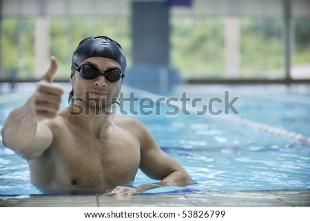 young healthy man with muscular body swims in swimming pool and representing healthy and recreation concept