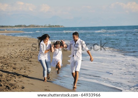 Happy Young Family In White Clothing Have Fun At Vacations On Beautiful