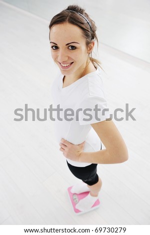 happy diet concept with young woman on pink scale at sport fitness gym club