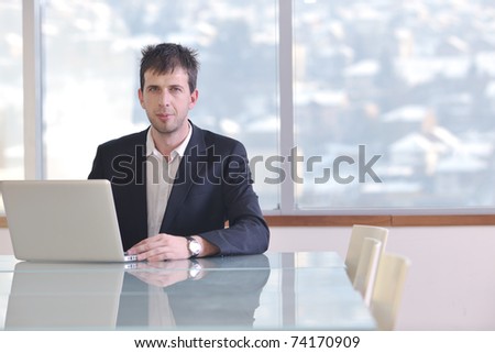 young business man lawyer with laptop alone in big bright   conference room