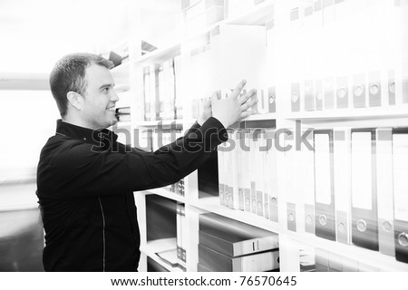 business man male adult in archive library looking and searching for book and documents representing storage and education concept