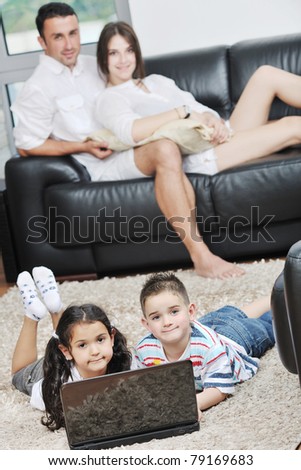 happy young family have fun and working on laptop at modern  home livingroom indoor