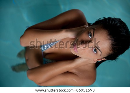 Closeup of pretty young lady have fun and posing  while relaxing in the swimming pool in luxury hotel