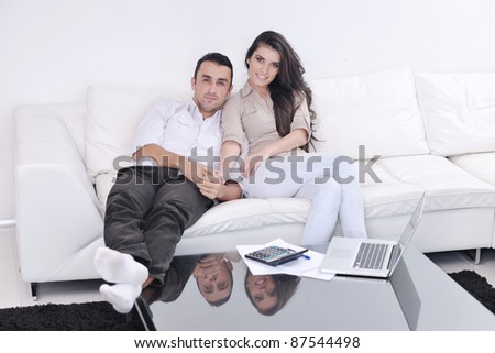 joyful couple relax and work on laptop computer at modern living room indoor home