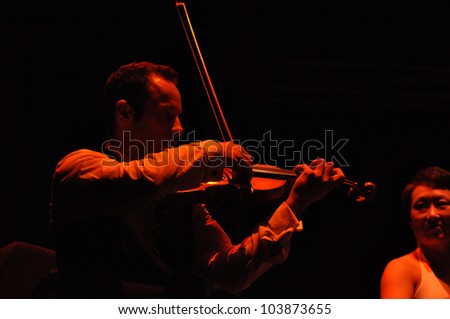 CLUJ NAPOCA, ROMANIA Ã¢Â?Â? MAY 29: Nicholas Crosa from Pink Martini pop-jazz band performs live on violin at the Sports Hall of Cluj, Romania, MAY 29, 2012 in Cluj-Napoca, Romania