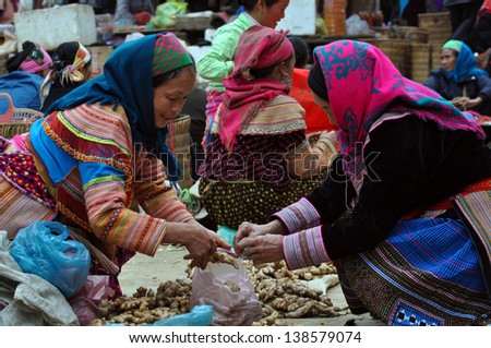 SAPA - FEB 23: Unidentified Flower H\'mong women from Sapa selling ginseng in the Sapa market. The Flower Hmong tribe is one of the famous minority tribes in Vietnam. On Feb 23, 2013 in Sapa, Vietnam