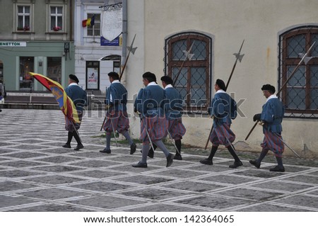BRASOV, ROMANIA - JUNE 7: Medieval royal guards marching through the Council Square. Brasov is one of the most popular saxon medieval city of Romania. In Brasov, Romania, on June 7, 2013.