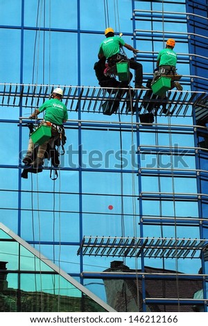 CLUJ NAPOCA - MAY 03: Unidentified workers washing the windows facade of a new build Transilvania bank before the official opening on May 03, 2011 in Cluj Napoca, Romania
