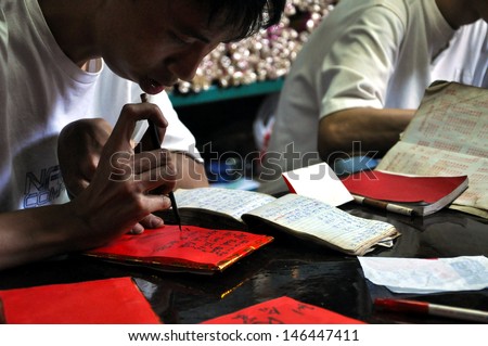 SAIGON - FEB 15: Young man write letter for everyone in lunar new year in Chua Ba Thien Hau temple. On February 15, 2013 in Saigon, Vietnam. This is a tradition of Vietnamese people in lunar new year.
