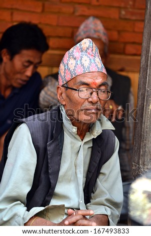 BHAKTAPUR, NEPAL - OCT 11: An old man resting in the historical city of Bhaktapur, Nepal on October 11, 2013. Bhaktapur is best known for its rich cultural heritage, especially its arts and crafts