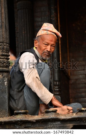 BHAKTAPUR, NEPAL - OCT 11: An old man resting in the historical city of Bhaktapur, Nepal on October 11, 2013. Bhaktapur is best known for its rich cultural heritage, especially its arts and crafts