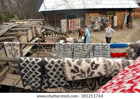 IEUD, ROMANIA - MARCH 20: Unidentified people washing their carpets in a traditional wooden whirlpool. Such methods are very common in the Romanian rural areas. On March 20, 2007 in Ieud, Romania