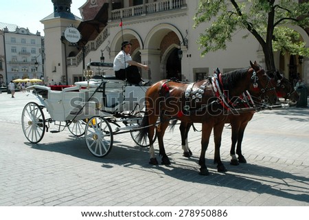 KRAKOW, POLAND - MAY 29: Horse carriages waiting for tourists in Krakow. Taking a horse ride in a carriage is very popular among tourists visiting Krakow. On May 29, 2005 in Krakow, Poland