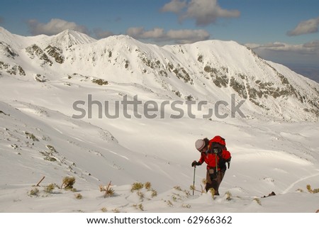 Alone climber reaching the summit of the mountain. Retezat mountains, Romania