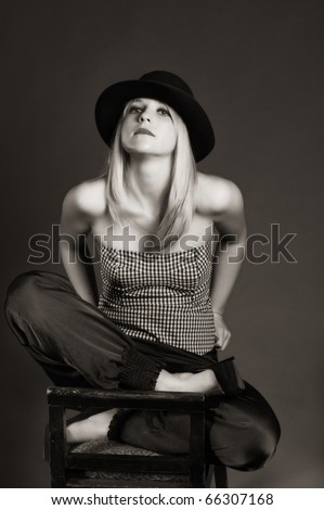 Provocative Sexy Blonde Woman With Hat Sitting On A Chair. Fashion Art ...