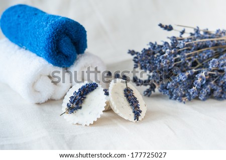 Blue and white towels, lavender bouquet and lavender soap on a linen napkin