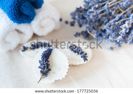 Blue and white towels, lavender bouquet and lavender soap on a linen napkin