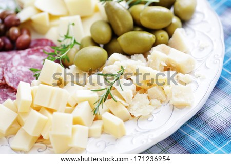 cheese and olives on a plate as a snack - food and drink