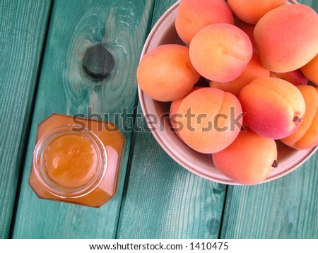 jar of apricot jam and some fresh apricots in bowl