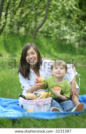 mother and son relaxing - family picnic in the forest