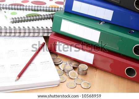 calendar files and coins on table - office work