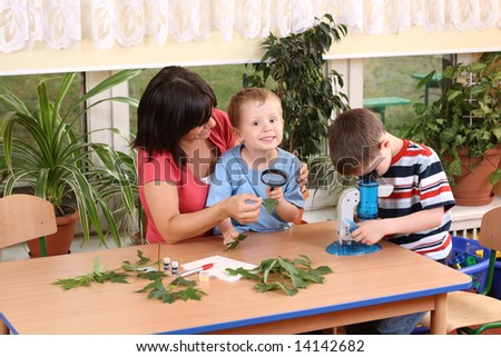 biology lesson in preschool - teacher and two boys