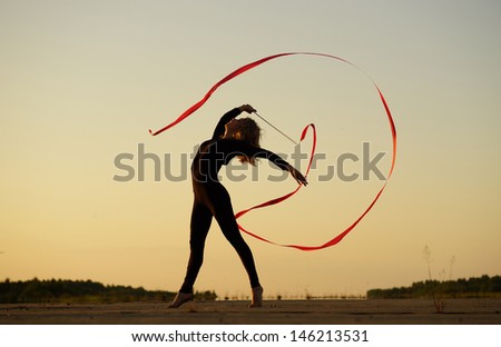 Professional gymnast woman dancer posing with ribbon