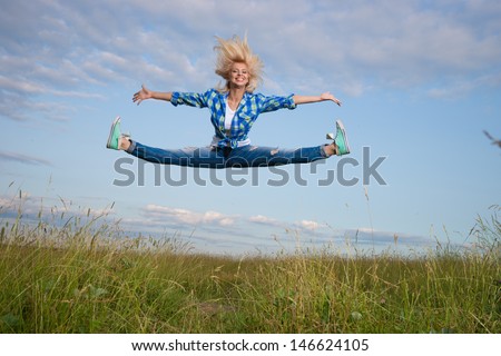 Professional gymnast woman jump in green grass field