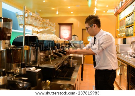 KUALA-LUMPUR - MAY 06: barman prepare coffee in airport cafe on May 06, 2014 in Kuala-Lumpur, Malaysia. Kuala Lumpur International Airport is one of the major airports of South East Asia.