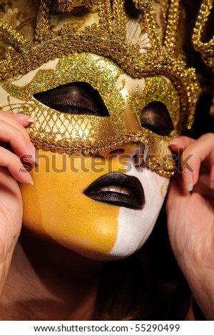 close-up of woman\'s face in golden half mask