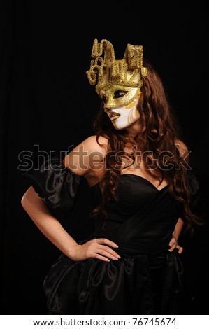 portrait of sexy woman in golden party mask isolated on black