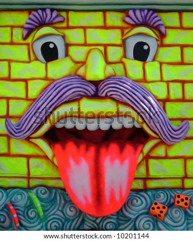 A carnival float depicting a moustached face with a tongue sticking out
