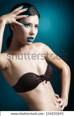 Beautiful and fashion asian woman posing over a blue background