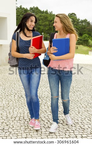 Two beautiful teenage students walking together in the school