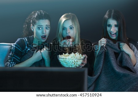 Teenage girls watching horror movie with popcorn 商業照片 © 