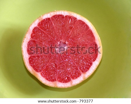 Closeup of ruby red grapefruit texture on a green plate