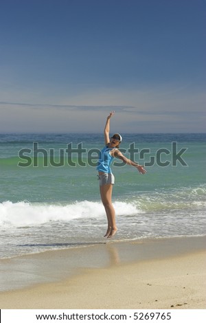 Beautiful woman jumping on a great day of summer on the beach