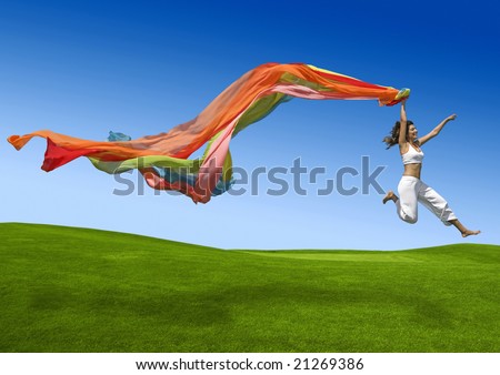 Athletic woman jumping on a green meadow