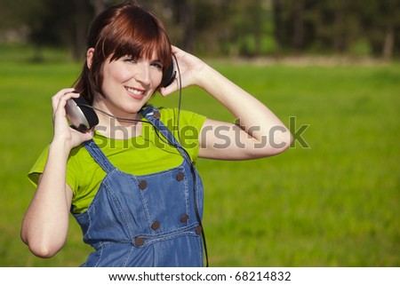 Portrait of a happy woman listen music on a beautiful spring day