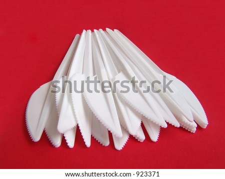 Plastic knives on red background