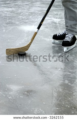 a hockey stick and puck and ice skates on the ice