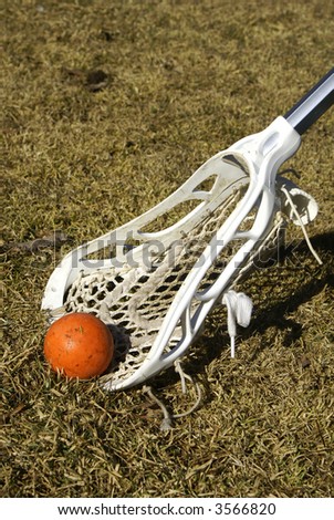 a white lacrosse stick scooping the ball off the ground