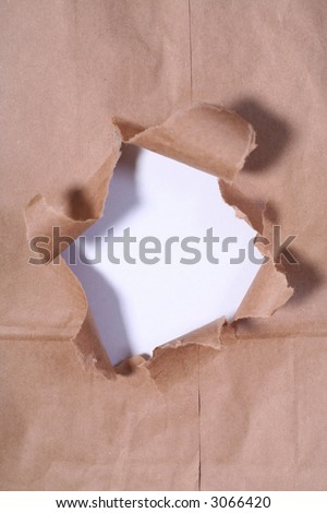 Hole in a brown paper bag backed with white paper